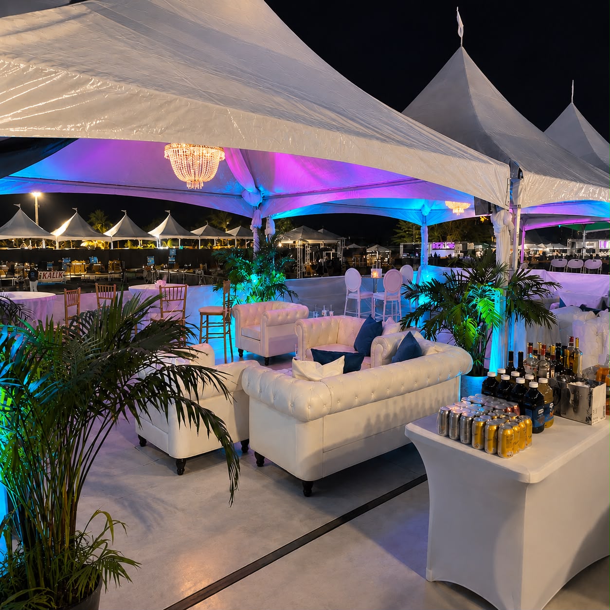 Lounge seating under a tent with colorful event lighting